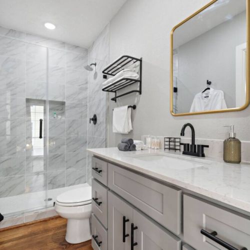 Primary bathroom  is fully stocked with all you need. Makeup pads, q-tips, and white robes included.