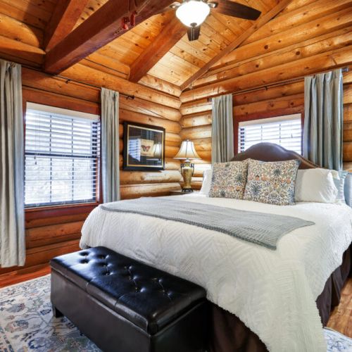 Rustic bedroom with smart TV, comfy bed, full-length mirror, and a chic sofa bench—all ready for you!