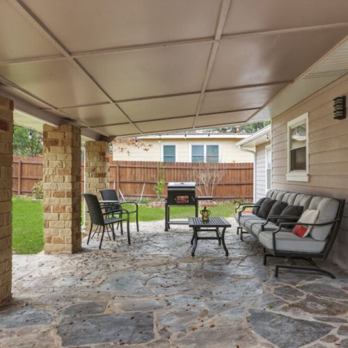 Private covered patio with charming patio seating. We also include a charcoal grill and a cornhole set!