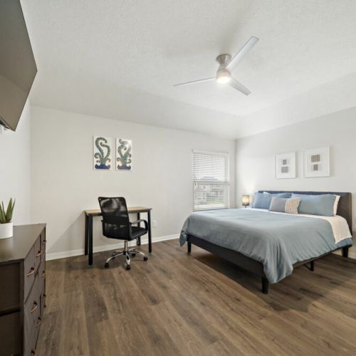 4th bedroom with a queen-size bed and a dedicated workspace.