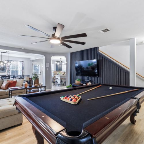 Full-size pool table included in the living room.