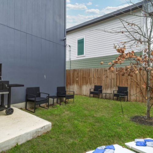 Private backyard with charming patio seating. We also include a charcoal grill and a cornhole set!
