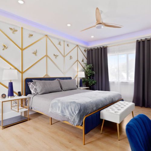 Primary bedroom with a king size bed, smart TV, attached bathroom, desk and electric fireplace