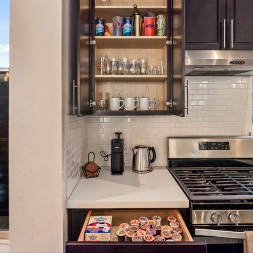 Keurig coffee machine with complimentary coffee pods, tea, sugar, cream, and sweetener