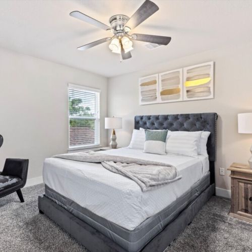 2nd bedroom with queen size bed and an accent chair.