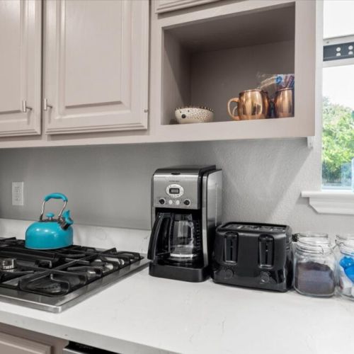 Cuisinart coffee maker with complimentary coffee, tea, sugar, and cream