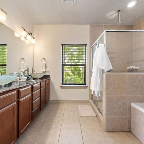 Primary bathroom with dual sinks, makeup pads, and q-tips.
