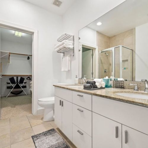 Primary bathroom with dual sinks, makeup pads, and q-tips.