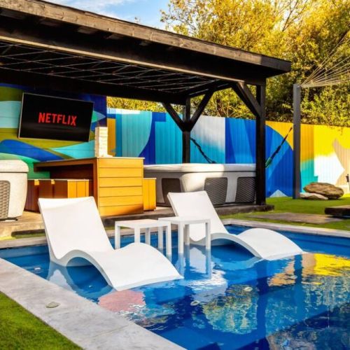 The sparkling blue pool invites you to relax, with loungers that seem to float just above the water’s surface