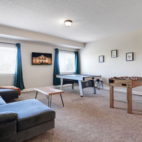 Game room with huge sectional sofa and smart TV.