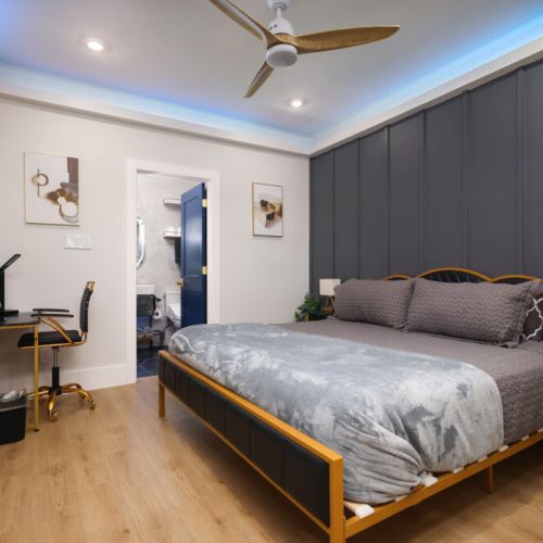 2nd bedroom with king size bed, smart tv, attached bathroom, desk and electric fireplace