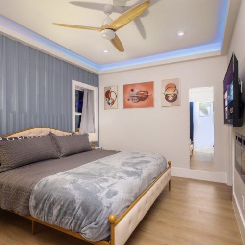 3rd bedroom with king size bed, smart tv, attached bathroom, desk and electric fireplace