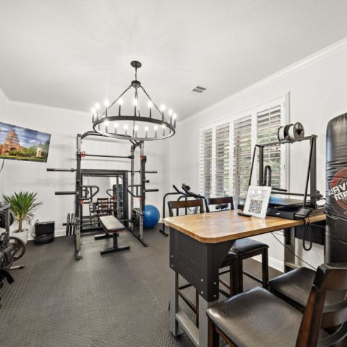 Gym w/ free weights, bicycle, squat rack, punching bag, wooden dummy, and more