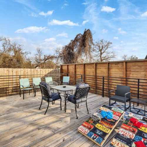 Private deck with a cornhole set, additional dining table that sits 4, and 2 seating areas.
