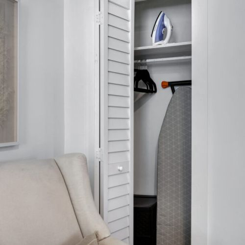 Bedroom closet available with iron and ironing board.