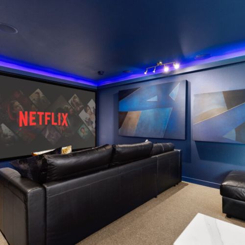 A dark, cozy cinema room where the large screen sets the stage for immersive movie nights
