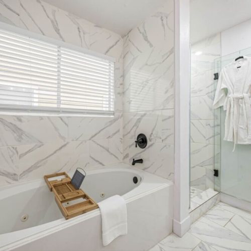 Luxurious standalone tub with bathtub tray. White robes included.