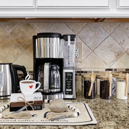 Ninja coffee machine with complimentary coffee,  decaf, tea, sugar, cream, and sweetener.