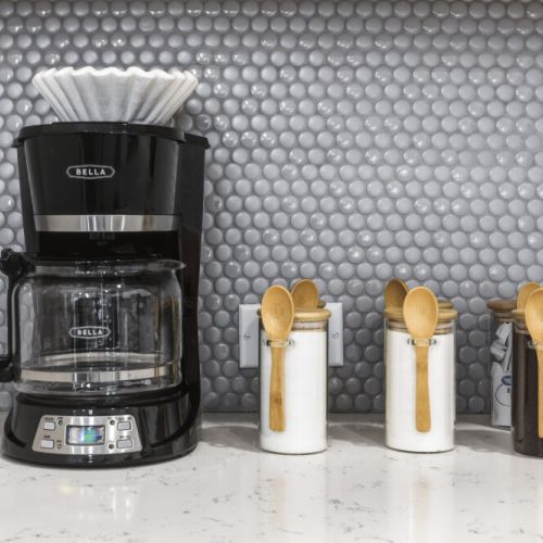 Coffee bar included with a drip coffee machine with complimentary coffee, decaf, tea, sugar, cream, and sweetener